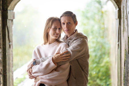Loving couple embracing in archway of old buildingの写真素材