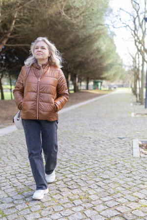 Senior woman enjoying walk in park during daytimeの写真素材