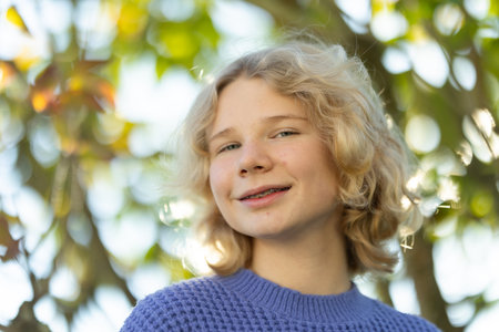 Blonde young woman smiling wearing dental braces outdoors