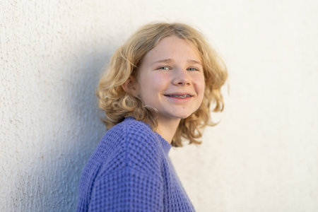 Young blonde girl smiling, showing dental braces