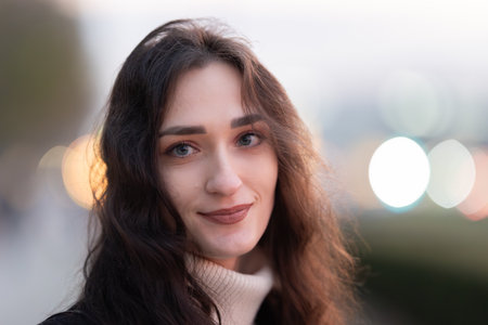 Young woman smiling with bokeh lights backgroundの写真素材