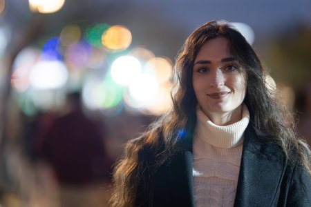 Young woman smiling in urban night setting with bokeh