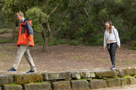 Young couple walking separate paths on outdoor trail