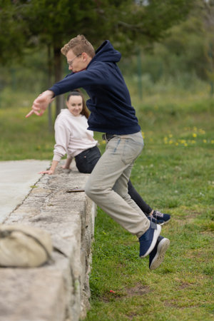 Young man jumping from wall with smiling womanの写真素材