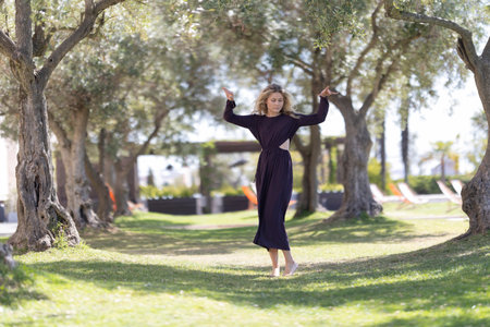 Barefoot woman dancing with graceful movement in a gardenの写真素材