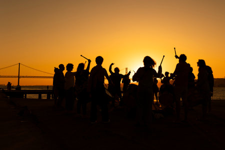A silhouette of drum players musicians against a sunsetの写真素材
