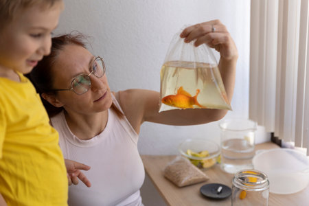 Mother and son preparing new goldfish pet habitatの写真素材