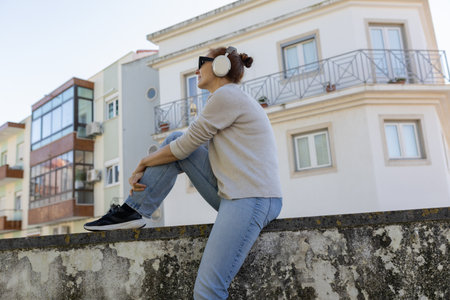 Woman listening music headphones enjoying urban city freedomの写真素材