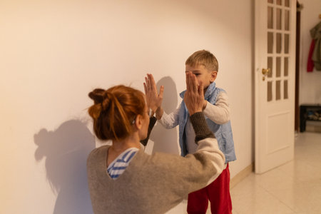Mother and child playing hand clapping game indoorsの写真素材