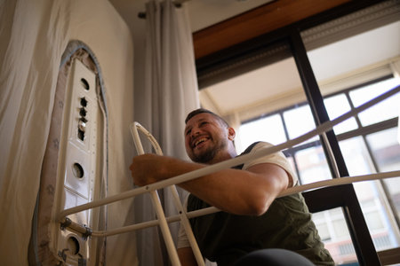 Happy man setting up an ironing board at home