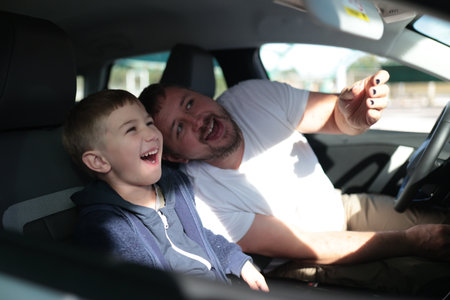 Father and son laughing having fun in car
