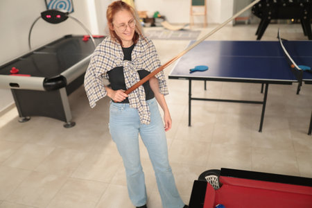 Woman holding pool cue ready to play billiards game