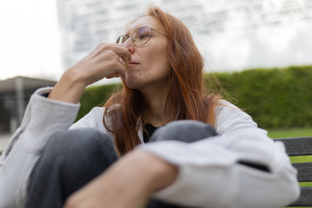 Redhead woman having thoughtful outdoor snackの写真素材