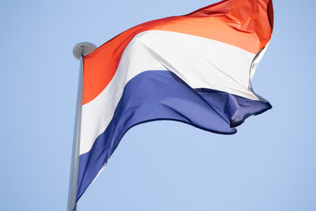 Netherlands flag waving proudly in clear blue skyの写真素材