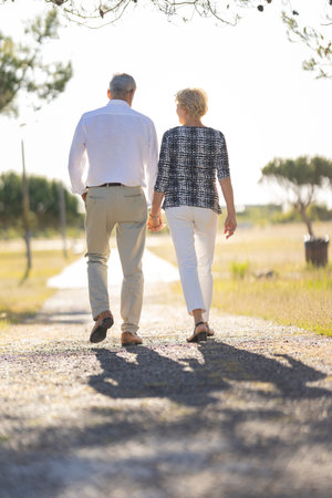 Senior couple holding hands walking future pathの写真素材