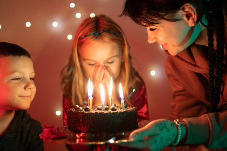 Little girl blowing out birthday candles making a wishの写真素材