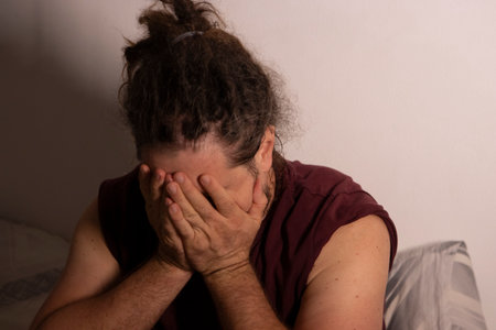 Man covering face in despair feeling sad and depressedの写真素材