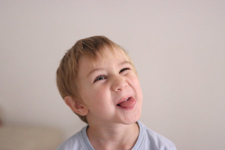 Young child making playful silly face sticking out tongue