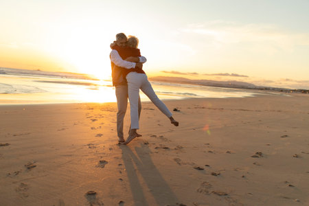 Senior couple embracing on beach during sunsetの写真素材