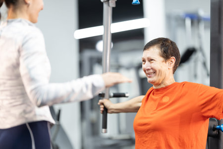 Senior woman training with personal coach in gym