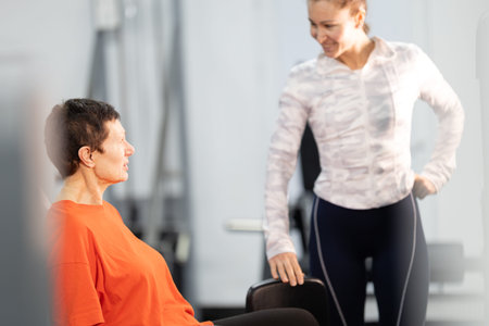 Senior woman training with personal coach in gym