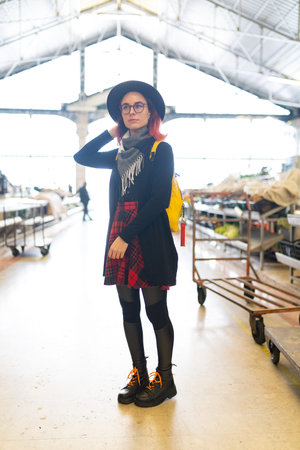 Young woman exploring an industrial urban space wearing plaid
