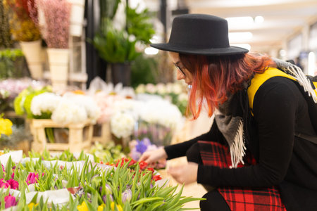 Young woman selecting colorful tulips in flower marketの写真素材