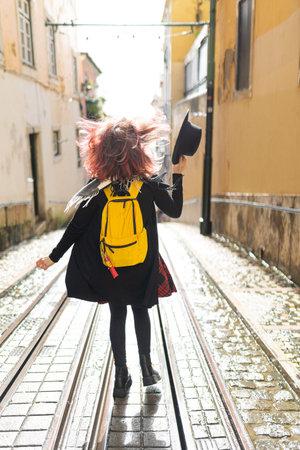 Traveler running with backpack on urban tram tracksの写真素材