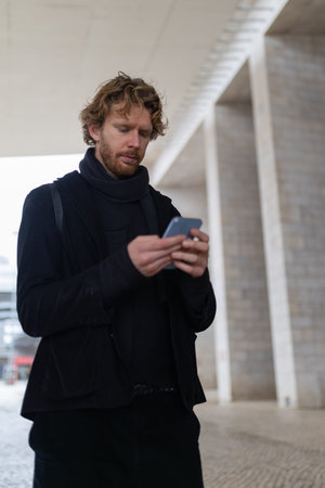 Young man connecting with smartphone technology in urban environmentの写真素材