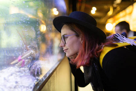 Woman observing seafood tank at market or restaurantの写真素材