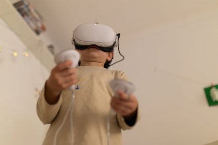 Child playing virtual reality game using headset and controllers