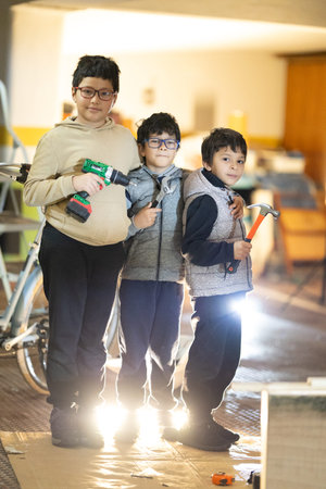 Three boys playing with tools learning handiwork skills