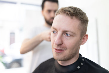 Client receiving professional haircut from skilled barberの写真素材