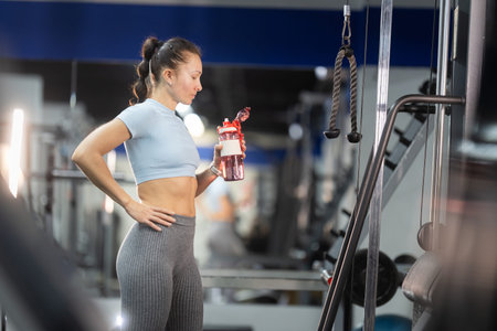 Woman hydrating during gym workout break