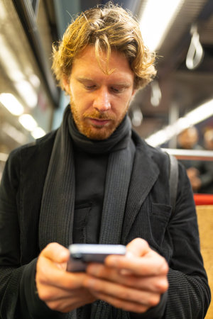 Man commuting using smartphone in subwayの写真素材