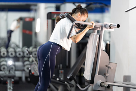 Woman exercising legs using gym fitness machine