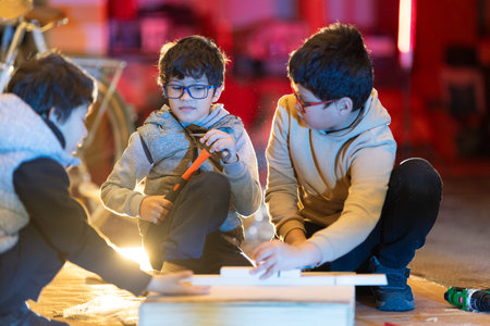 Kids hands-on learning carpentry skills in workshopの写真素材