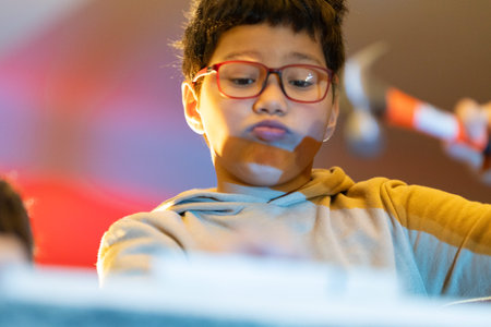 Young boy learning building skills with a hammerの写真素材