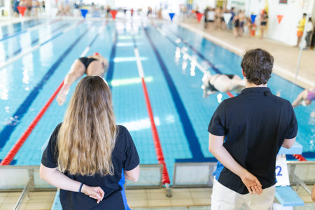 Coaches observing swimmers during indoor training session
