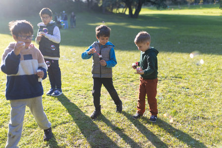 Young boys blowing soap bubbles enjoying outdoor play