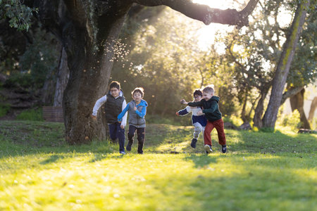 Happy boys running and playing outdoors enjoying childhoodの写真素材