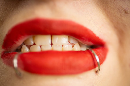 Woman showing red lips with lip piercing