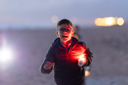 Boy excited holding red light stick on beach