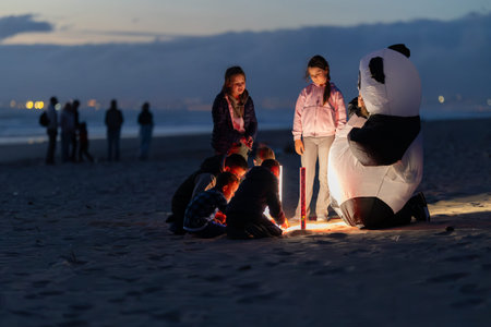 Children launching lantern on beach at dusk