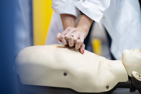 Student hands performing cpr on medical training dummy
