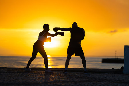 People training boxing outdoors during golden sunset
