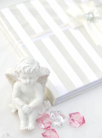 A little miniature statue of a white angel with wings on a white backgroundの写真素材
