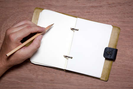 hand writing blank notebook on wood background