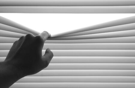 Closeup of hand opening venetian blinds. Place for textの写真素材