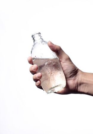 Holding water from bottle glass isolated white background.の写真素材